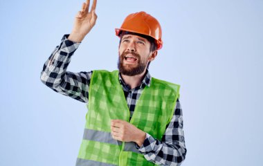 Mavi arka plan ve yansıtıcı yeleği olan sert şapka mühendisi.