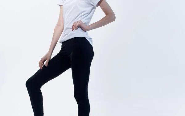 Mulher Fitnessport em leggings mantém a mão no fundo da luz da cintura — Fotografia de Stock