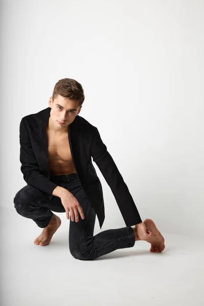Hombre guapo en cuclillas chaqueta negra moda posando estilo atractivo — Foto de Stock