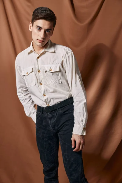 Hombre en camisa blanca estudio estilo moderno confianza en sí mismo marrón beige fondo — Foto de Stock