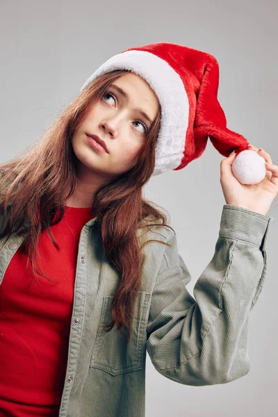 Jolie fille en chapeaux de Noël avec pompon sur fond gris — Photo