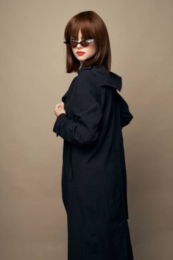 Güzel bayan siyah ceket zarif bir şekilde izole bir arka planda gülümsüyor. 