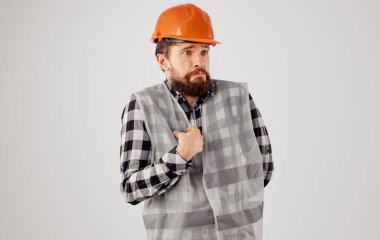 İnşaat işindeki adam üniformalı, turuncu şapka takan, profesyonel bir inşaat işçisinin duyguları.