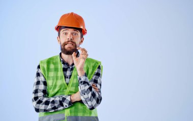 Mavi arka plan ve yansıtıcı yeleği olan sert şapka mühendisi.