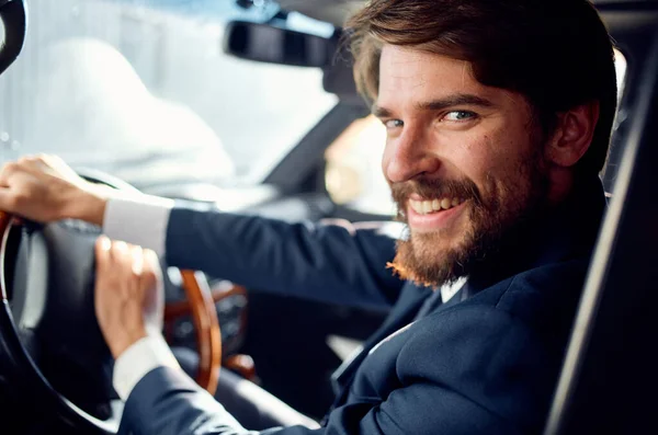 bearded man in suit driving a car luxury trip lifestyle