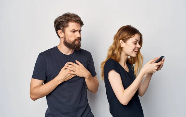 Jovem casal com telefone nas mãos insatisfação com a tecnologia — Fotografia de Stock
