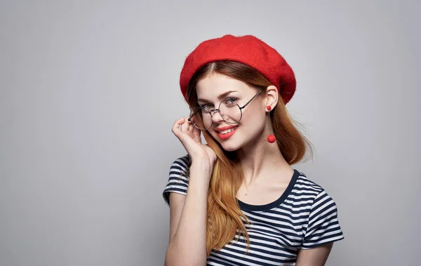 Mooie dame in t-shirt gebaren met handen bril rood hoed model — Stockfoto