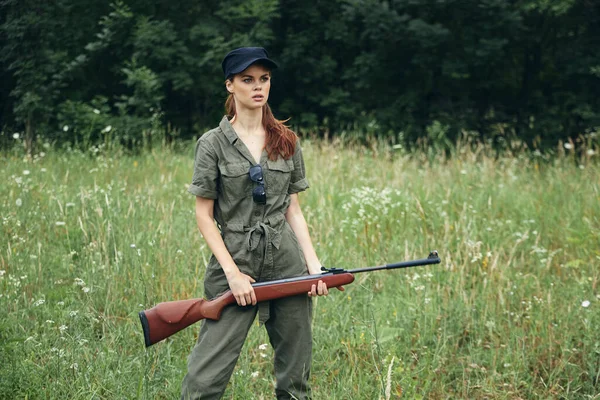 Mulher armas em mãos macacão verde viajar no exterior preto cap — Fotografia de Stock