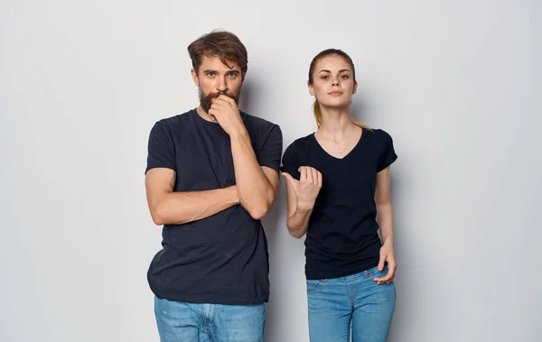 Cheerful man and woman in black t-shirts studio casual clothes isolated background — Stock Photo, Image