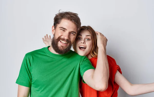Веселый мужчина и женщина в красочных футболках семейные эмоции радость изолированный фон — стоковое фото