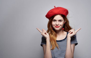 Çizgili tişörtlü, parlak makyaj küpeli seksi bir kadının portresi.