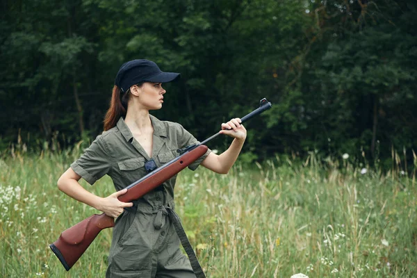 여자 군인이 숲의 배경에 맞서 총을 숨기고 있다 — 스톡 사진