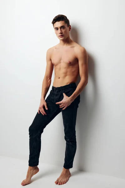 Sexy guy in jeans and naked torso light background — Stock Photo, Image