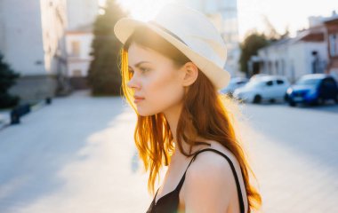 Sokakta güneş gözlüklü güzel bir kadın yürüyor.