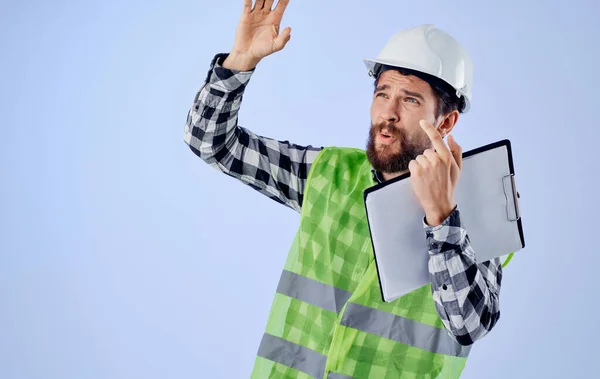 Un uomo in uniforme da lavoro un casco bianco costruzione documenti di sicurezza Professionale — Foto Stock