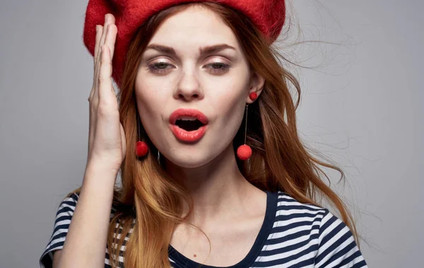 Porträt einer romantischen Frau in einem hellen Make-up Baskenmütze Ohrringe gestreiftes T-Shirt — Stockfoto