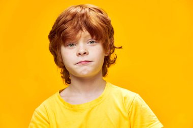 Kızıl saçlı çocuk yüzü, sarı tişörtü ve çocukluğu kapat. 