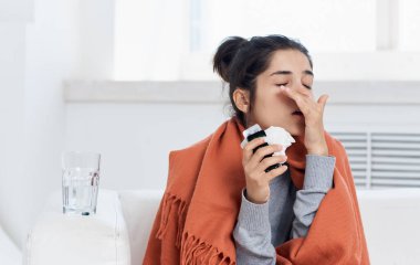 Alerjik reaksiyon. Peçeteli genç kadın baş ağrısı.