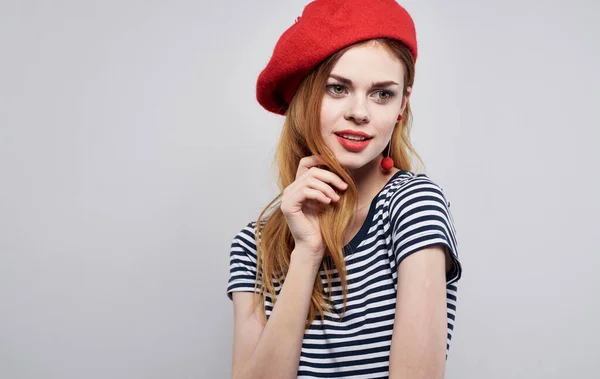 Modelo de mujer sexy en un tocado y una camiseta a rayas sobre un fondo claro con vista recortada maquillaje —  Fotos de Stock