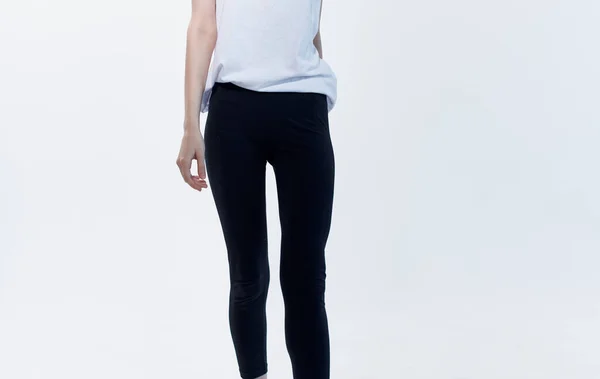 Donna indoor su sfondo chiaro e leggings neri in t-shirt bianca — Foto Stock