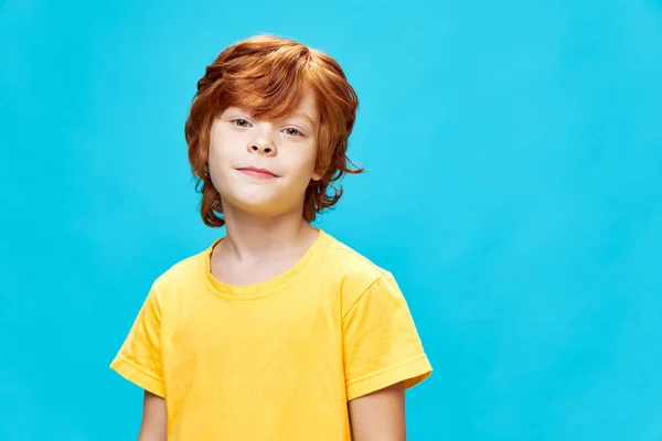 Rödhårig pojke gul t-shirt studio kul — Stockfoto