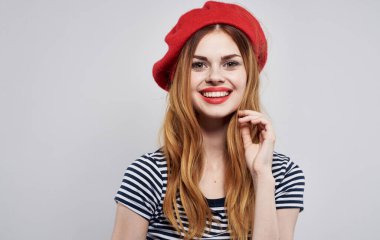 Kırmızı bereli ve çizgili tişörtlü çekici bir kadın. Güzel bir gülümseme modeli.