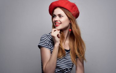 Çizgili tişörtlü, parlak makyaj küpeli seksi bir kadının portresi.