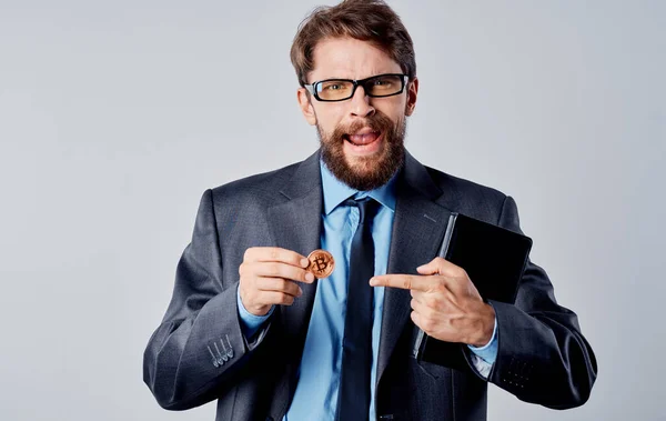 Ein Geschäftsmann im Sakko hält eine Kryptowährung in der Hand, Bitcoin-Wechselkurse — Stockfoto