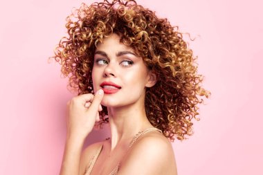 Kıvırcık saçlı rüya gibi kadın yan tarafa bakıyor.