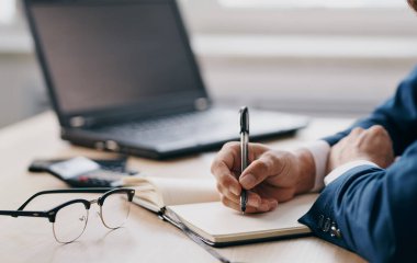 Erkek el işleri finans belgeleri bardaklar dizüstü bilgisayar ofisi ve not defteri