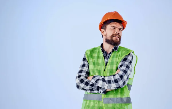 construction worker in orange hard hat on blue background and plaid shirt reflective vest