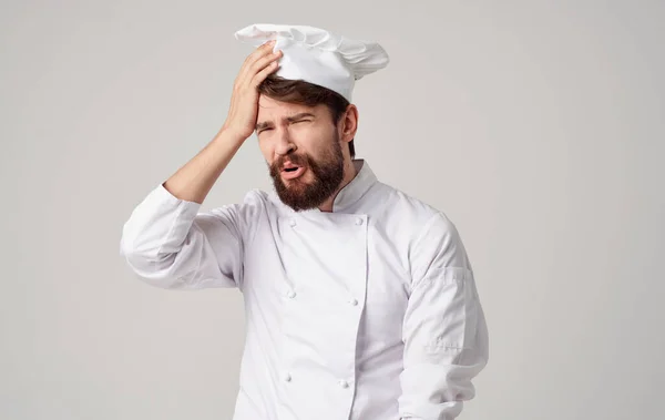 Samec kuchař uniforma čelenka světlo pozadí oříznutý pohled — Stock fotografie