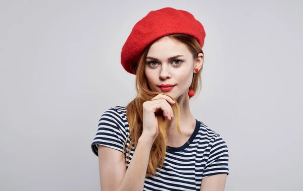 Sexig kvinna modell i en huvudbonad och en randig T-shirt på en lätt bakgrund med makeup beskärd vy — Stockfoto