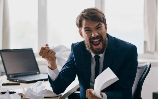 Homem agressivo com folhas de papel nas mãos irritabilidade estresse negócio laptop finanças — Fotografia de Stock