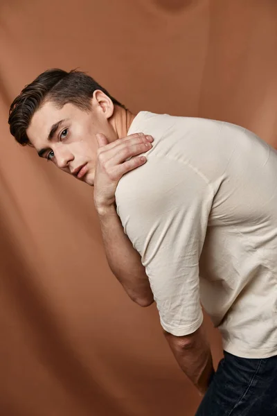 Leuke man witte blouse emoties poseren bruine achtergrond — Stockfoto