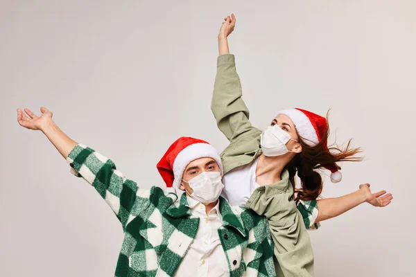 Uomini e donne felici con cappelli festosi gesticolano con le mani su uno sfondo leggero — Foto Stock