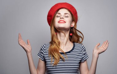 Kırmızı bereli ve çizgili tişörtlü bir kadın arka planda kırpılmış görünüyor. Boşluğu kopyala