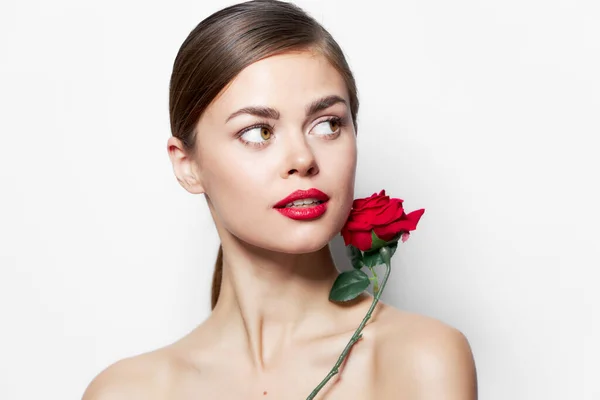 Brunetka róża w pobliżu twarzy nagie ramiona spojrzeć na bok Czerwone usta jasny makijaż — Zdjęcie stockowe