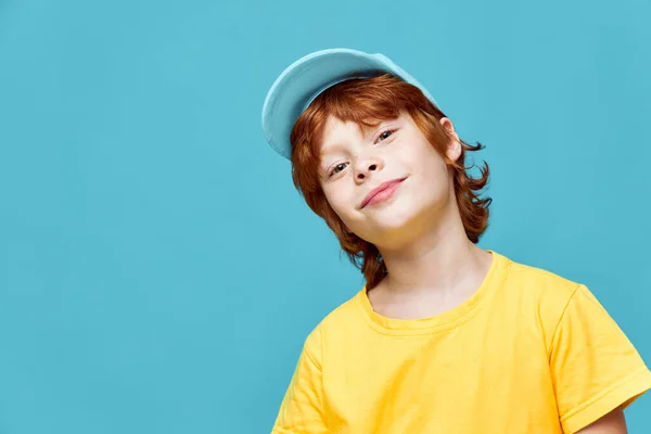 Retrato de una cabeza de niño de pelo rojo inclinada hacia un lado tapa azul Copiar espacio — Foto de Stock