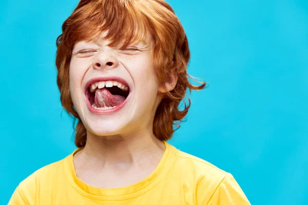 Pelirroja chico ojos cerrado sobresaliendo lengua divertido amarillo camiseta —  Fotos de Stock