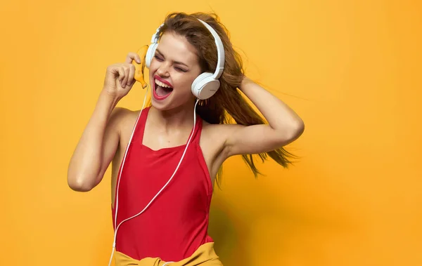 Mujer alegre en los auriculares Camiseta roja música de fondo amarillo —  Fotos de Stock