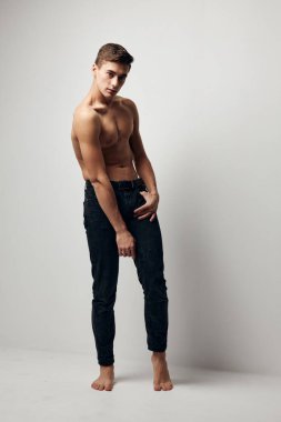 Geniş bir arka planda kolları şişmiş, seksi bir adam.