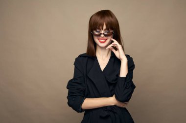 Seksi, modaya uygun kıyafetler bej arka planda gülümseyen iyi bir ruh hali. 