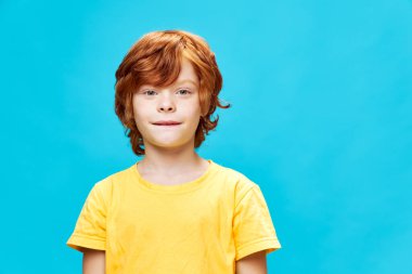 Kızıl saçlı çocuk dudak sarısı tişörtünü yakından ısırdı. 