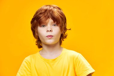 Sarı tişört giyen kızıl saçlı çocuk çocukluğunu iple çekiyordu.