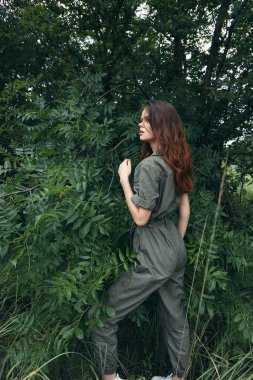 Ormandaki kadın Tulumuyla yeşil çalıların yanında Temiz hava