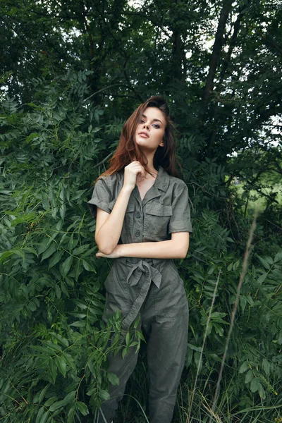 Retrato de una mujer en mono verde mano cerca de árboles de la cara —  Fotos de Stock