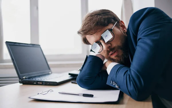 Homem de negócios dormindo no trabalho usando óculos com folhas de papel — Fotografia de Stock