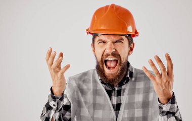 Mimar ellerini turuncu bir başlıkla hafif bir arka plan ve yansıtıcı bir yelek ile hareket ettirir.