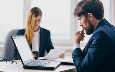 Ofis çalışanlarının masasında dizüstü bilgisayarı olan kadın ve erkek yönetici.